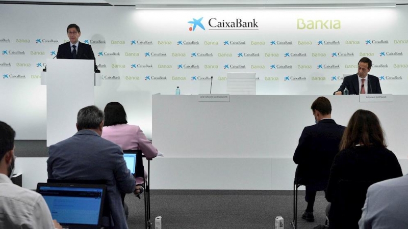 El presidente de Bankia, que los será de la nueva entidad, José Ignacio Goirigolzarri (i), y el consejero delegado de CaixaBank, que, igualmente, mantendrá el cargo de la nueva entidad, Gonzalo Gortázar (d), durante la rueda de prensa para presentar el ac