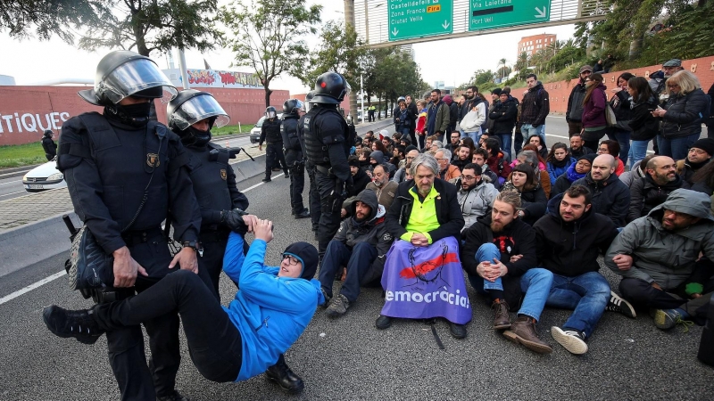 Una de les imatges de la vaga general del 8 de novembre de 2017, quan diversos Mossos van retirar un home de la calçada de les Rondes. ALBERT GEA/ REUTERS