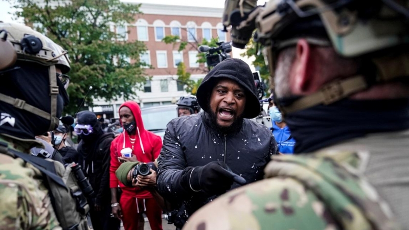 Un activista de Black Lives Matter se enfrenta a miembros de una milicia un día después de que un gran jurado que consideraba el asesinato en marzo de Breonna Taylor, votara a favor de acusar a uno de los tres policías blancos. REUTERS / Bryan Woolston