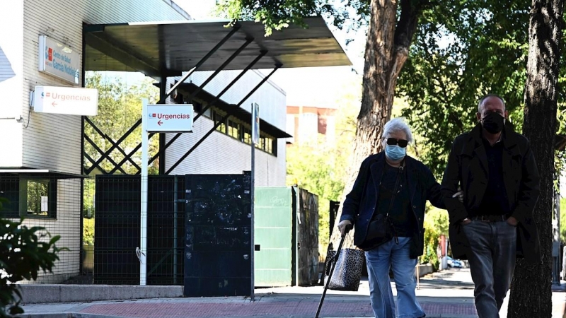 MADRID, 25/09/2020.- Dos personas pasan delante del centro de salud García Noblejas, en el distrito madrileño de Ciudad Lineal, este viernes. La Comunidad de Madrid ampliará a partir del próximo lunes, 28 de septiembre, las restricciones de movilidad vige