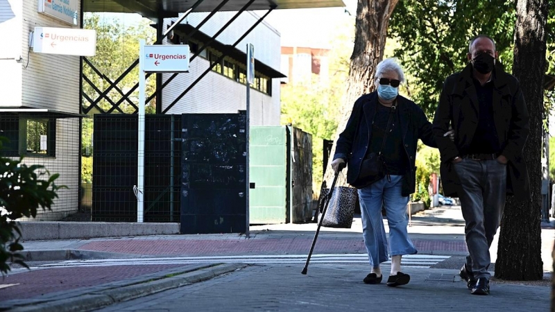 MADRID, 25/09/2020.- Dos personas pasan delante del centro de salud García Noblejas, en el distrito madrileño de Ciudad Lineal, este viernes. La Comunidad de Madrid ampliará a partir del próximo lunes, 28 de septiembre, las restricciones de movilidad vige
