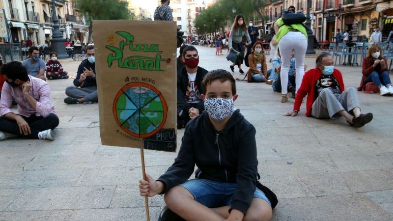 Manifestant amb una pancarta reivindicativa en la protesta organitzada a Tarragona per denunciar l'emergència climàtica. ACN/Mar Rovira