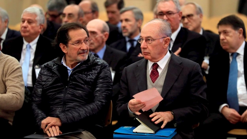 Fotografía de noviembre de 2018 del expresidente de Bankia Rodrigo Rato (d) junto al exconsejero de Caja Madrid José Antonio Moral Santín (i), durante la primera sesión del juicio por la salida a Bolsa de la entidad en la Audiencia Nacional. EFE/Fernando