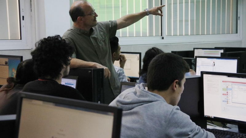 Una aula d'informàtica de l'institut Baix Camp de Reus, amb un professor entre els alumnes. Sívlia Jardí | ACN