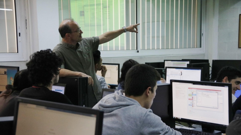 Una aula d'informàtica de l'institut Baix Camp de Reus, amb un professor entre els alumnes. Sívlia Jardí | ACN