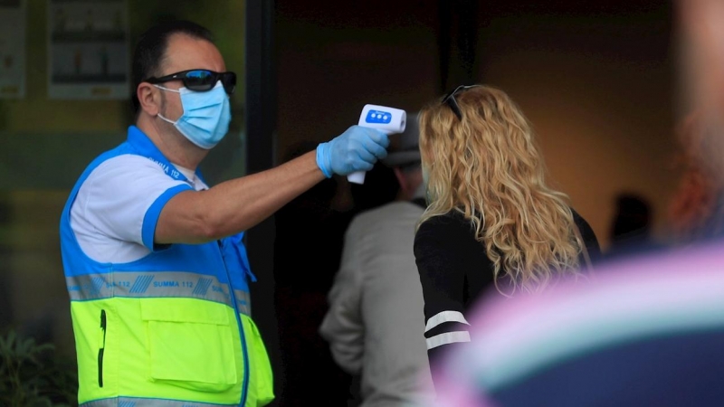 Un sanitario toma la temperatura a una mujer. EFE/Fernando Alvarado/Archivo