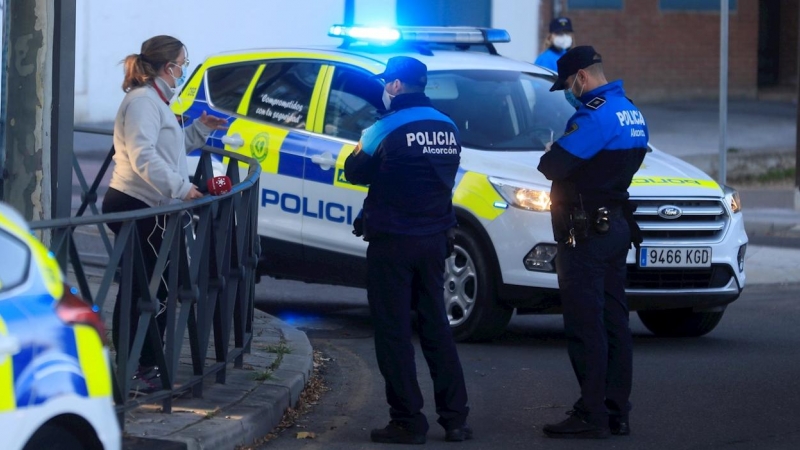 Una patrulla de la policía local conversa con una vecina este lunes, en la primera jornada de restricciones aplicadas a las áreas sanitarias de Miguel Servet y Doctor Trueta de la localidad madrileña de Alcorcón. EFE/Fernando Alvarado