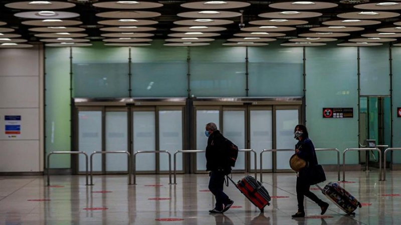 Dos personas en el aeropuerto de Barajas en Madrid / EFE