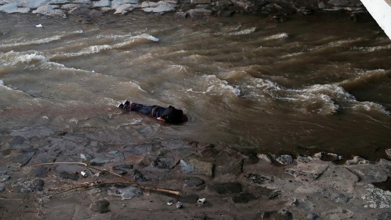 Un manifestante yace en el río después de caer de un puente durante una protesta contra el Gobierno de Chile, en Santiago. REUTERS.