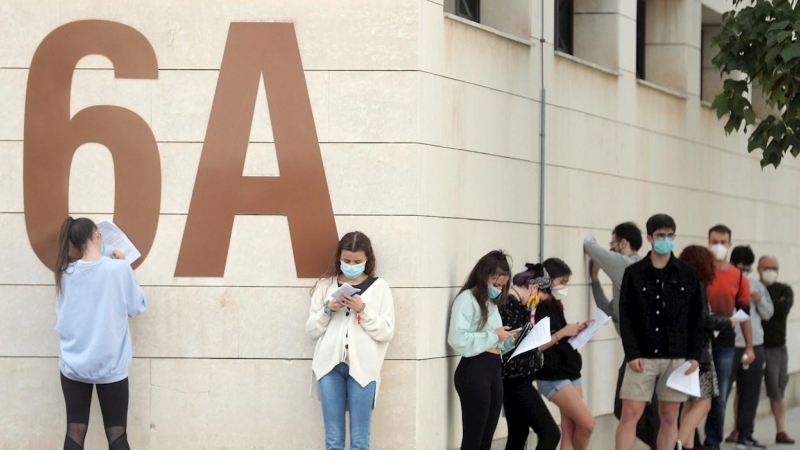 Alumnos de la Universidad Politécnica de Valencia (UPV) guardan cola en el exterior de las instalaciones del pabellón de baloncesto donde se realizan pruebas PCR. EFE/Kai Försterling