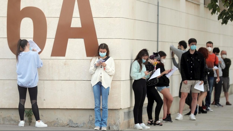 Alumnos de la Universidad Politécnica de Valencia (UPV) guardan cola en el exterior de las instalaciones del pabellón de baloncesto donde se realizan pruebas PCR. EFE/Kai Försterling