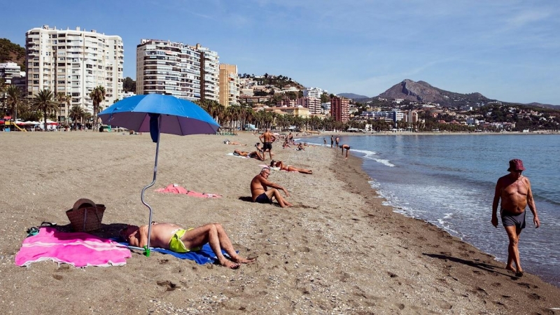 Varias personas disfrutan del buen tiempo en la playa de la Malagueta en Málaga, hoy martes cuando las temperaturas irán en ascenso en toda Andalucía. EFE/Jorge Zapata.