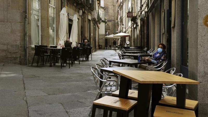 Una mujer permanece sentada en una terraza del barrio de O Couto el mismo día en el que han prohibido las reuniones entre no convivientes ante el aumento de contagios de covid-19 en Ourense.- ROSA VEIGA / EUROPA PRESS