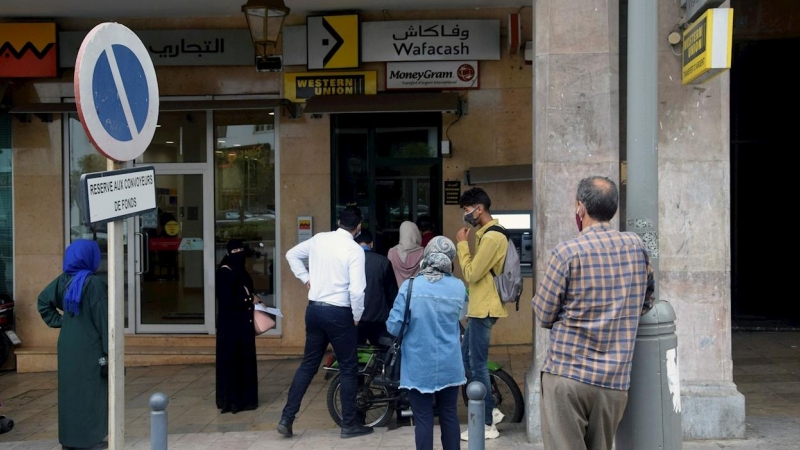 Gente haciendo cola ante una oficina de remesas en Rabat. - EFE