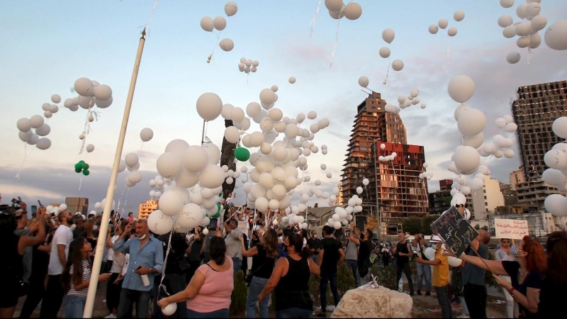 Manifestantes lanzan al aire globos con los nombres de los fallecidos en la explosión. - EFE