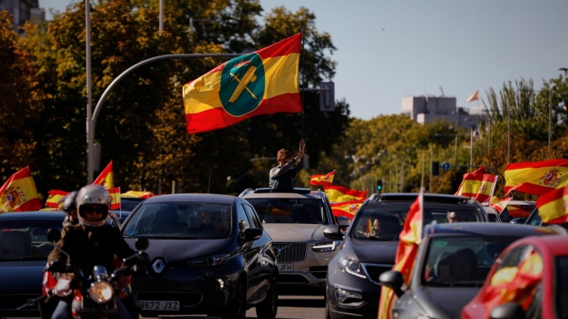 Una bandera de España con el símbolo de la Guardia Civil ondea entre una caravana de coches durante la manifestación convocada por Vox. /Europa Press