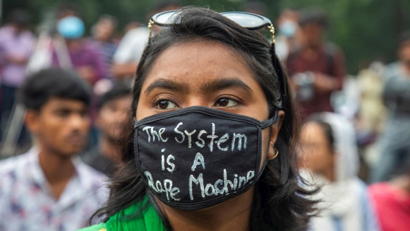 Una estudiante con una mascarilla que dice 'El sistema es una máquina violadora' participa en una protesta contra la violación y las agresiones sexuales en Dhaka, Bangladesh. /EFE