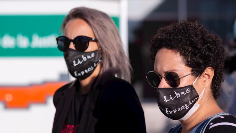 14/10/2020.- Dos mujeres con mascarillas a las puertas de la Ciudad de la Justicia de Málaga, antes de comenzar hoy el juicio contra una mujer tras participar en la 'Gran procesión del Santo chumino rebelde' el 8 de marzo de 2013. / EFE - Carlos Díaz