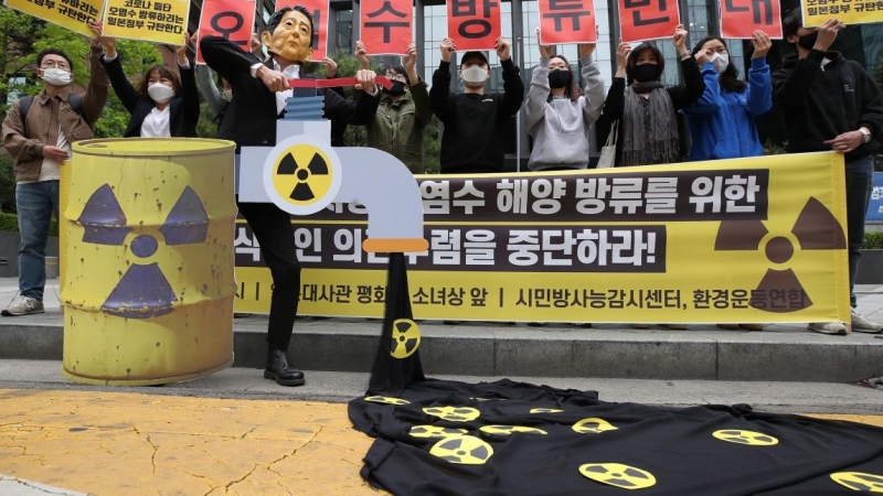 Un manifestante con una máscara que representa al primer ministro japonés simula la eliminación de agua radiactiva durante una manifestación para oponerse a la liberación de agua con materiales radiactivos de Fukushima.  -/YNA/dpa / Europa Press / Archivo