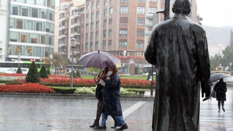 Varias personas se protegen de la fuerte lluvia en Bilbao. EFE/LUIS TEJIDO/Archivo