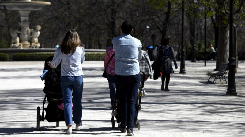 Unos padres pasean a sus hijos en sillitas de bebé por el Parque del Retiro en Madrid. /Europa Press