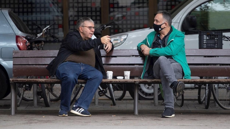 GRAFCAT3270. BARCELONA, 19/10/2020.- Dos hombres toman café en un banco del centro de Barcelona este lunes cuando las cifras de la COVID siguen en aumento en Cataluña (2.835 nuevos contagios en las últimas horas) a la espera que las restricciones den resu