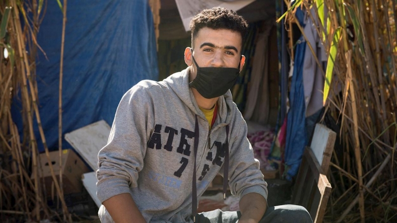 Ahmed vive en una chabola con tres colchones, construida entre cañas junto al cauce seco y lleno de basura que pasa al lado del CETI de Melilla.- EFE/Jesús Blasco de Avellaneda