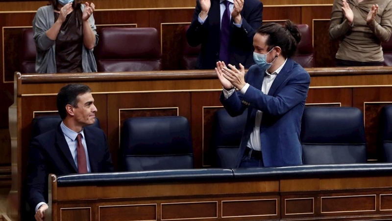 El presidente del Gobierno, Pedro Sánchez, es aplaudido por el vicepresidente segundo, Pablo Iglesias (d) y sus compañeros de partido tras su intervención en la moción de censura de VOX al gobierno de coalición, en el Congreso de los Diputados este miérco