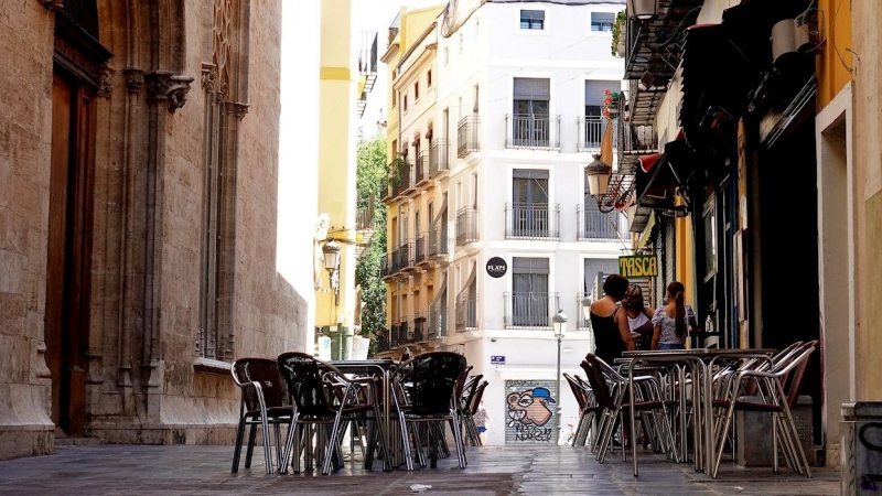 La terraza vacía de un bar frente al edificio de La Lonja, en el centro histórico de Valéncia. EFE/Manuel Bruque