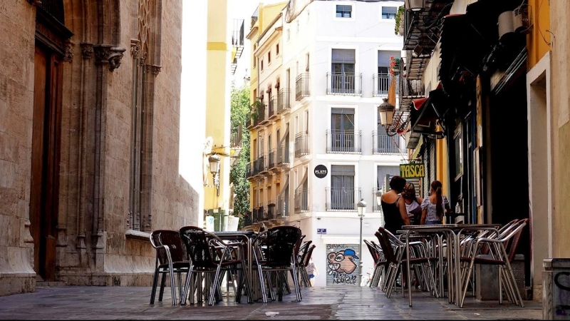 La terraza vacía de un bar frente al edificio de La Lonja, en el centro histórico de Valéncia. EFE/Manuel Bruque