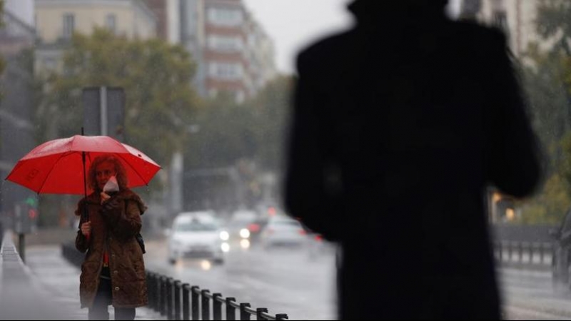 Dos transeúntes caminan entre la lluvia por las calles del centro de Madrid esta mañana de martes. EFE/ Mariscal