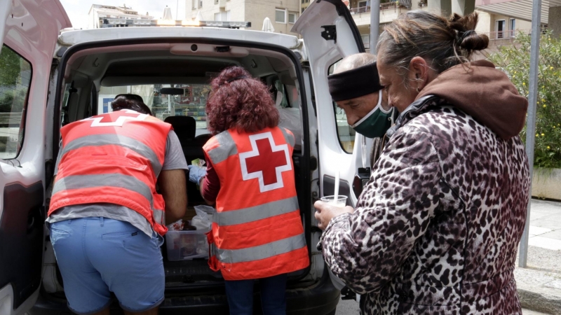 Voluntaris de la Creu Roja distribuint aliments als sensellar. ACN/Marina López