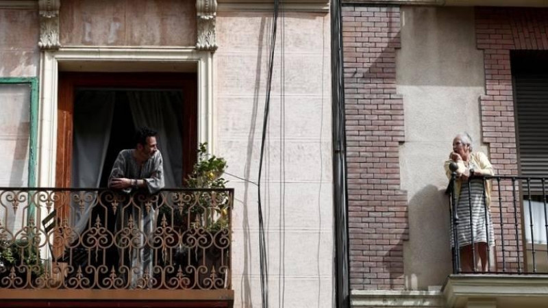 Dos vecinos conversan en el balcón de sus casas durante el confinamiento. EFE/Mariscal