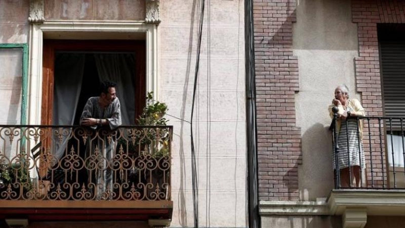 Dos vecinos conversan en el balcón de sus casas durante el confinamiento. EFE/Mariscal