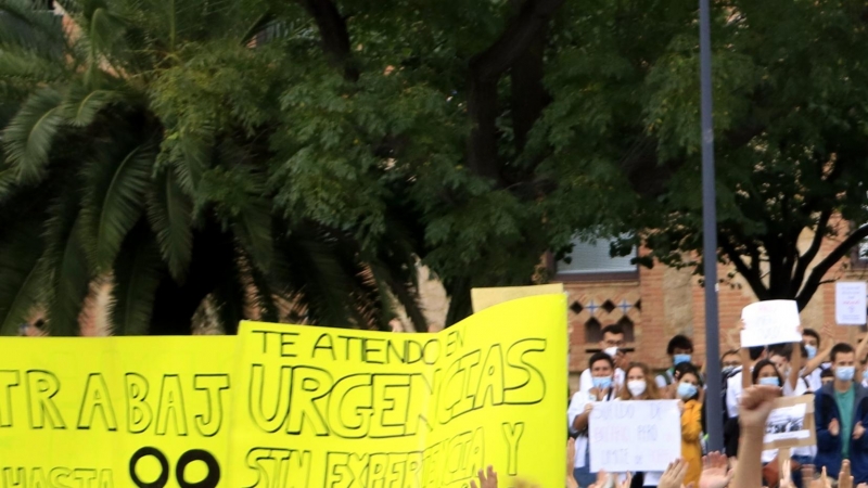 Metges interns residents (MIR) asseguts i picant de mans davant del Departament de Salut en una concentració en el marc de la primera jornada de la vaga del col·lectiu per reclamar millores formatives i laborals. LAURA FÍGULS / ACN