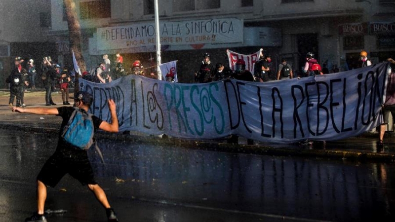 Manifestantes se enfrentan a los carabineros durante una nueva jornada de protestas en contra del gobierno del presidente de Chile, Sebastián Piñera, este viernes en Plaza Italia, ahora conocida como Plaza de la Dignidad, en Santiago. Con consignas a favo