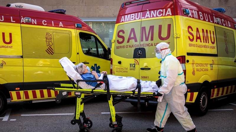 Un sanitarios con equipo de protección especial para evitar contagios de coronavirus, traslada a un paciente de una ambulancia a urgencias del Hospital Clínico de València. EFE/ Biel Aliño