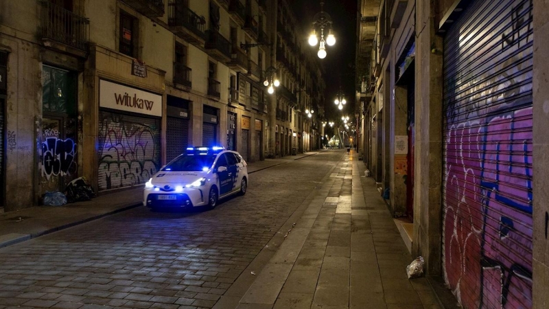 Una patrulla de la Guardia Urbana recorre la Calle Ferran de Barcelona durante el segundo día de la aplicación del 'toque de queda' en vigor desde el pasado domingo.