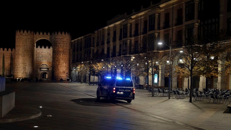 24/10/2020.- Un coche de la Policía patrulla por la plaza de Santa Teresa, vacía por el toque de queda en Ávila.