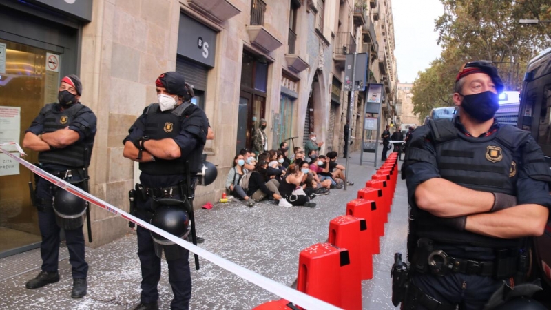 El cordó policial en primer terme i de les persones concentrades a les portes d'un habitatge per evitar el desnonament. Miquel Codolar | ACN