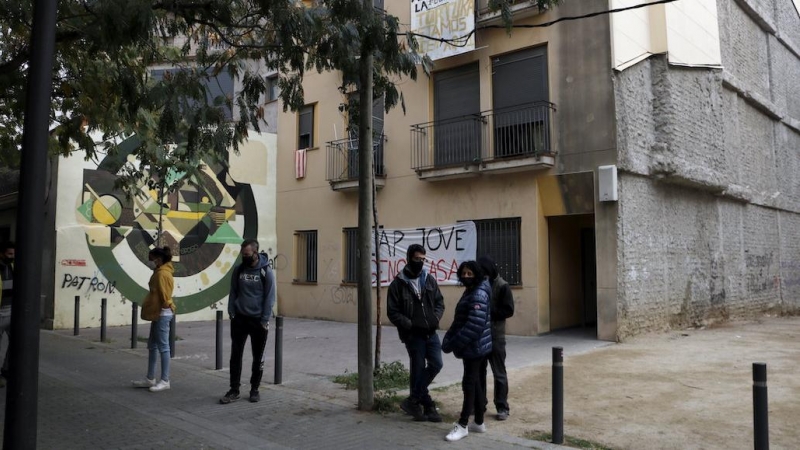 Diverses persones davant d'un bloc ocupat per joves a Manresa.