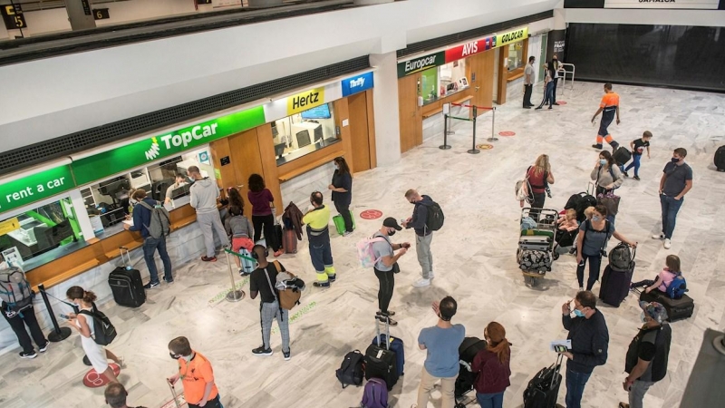 Varios turistas hacen cola ante una oficina de alquiler de vehículos a su llegada al aeropuerto César Manrique de Lanzarote.