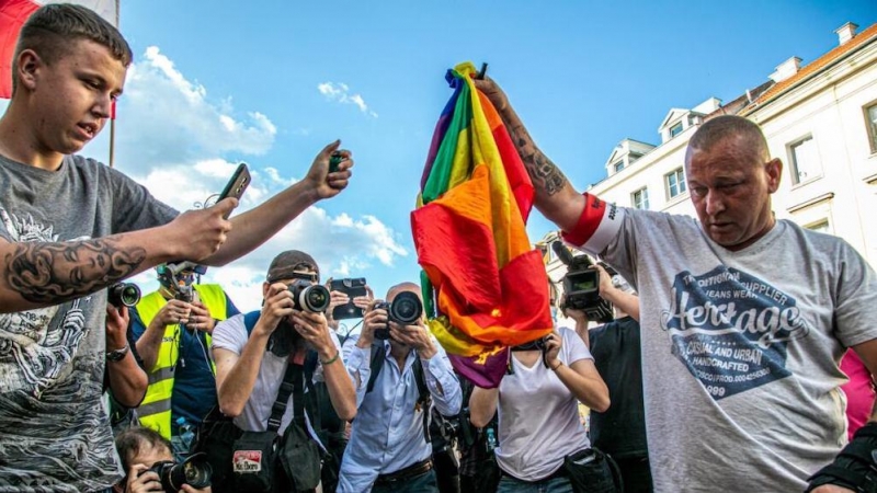 Varias personas se disponen a quemar una bandera LGTBI en Polonia.