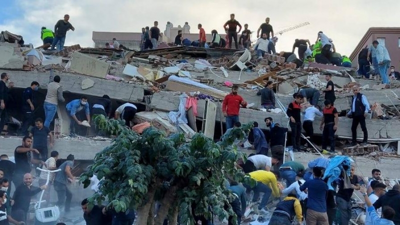 Vecinos ayudan en las labores de búsqueda de supervivientes entre los escombros de los edificios derrumbados por el terremoto que ha sacudido Izmir (Turquía).
