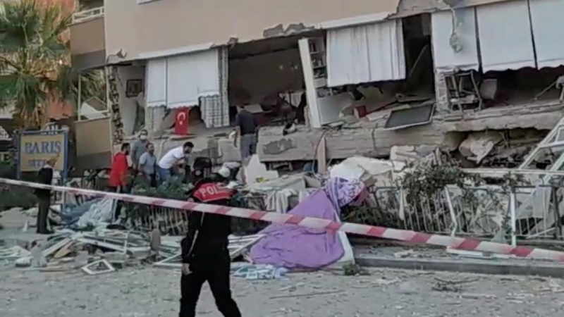 Personas buscan sobrevivientes en un edificio derrumbado después de que un fuerte terremoto sacudió el mar Egeo donde algunos edificios colapsaron en la provincia costera de Izmir, Turquía.