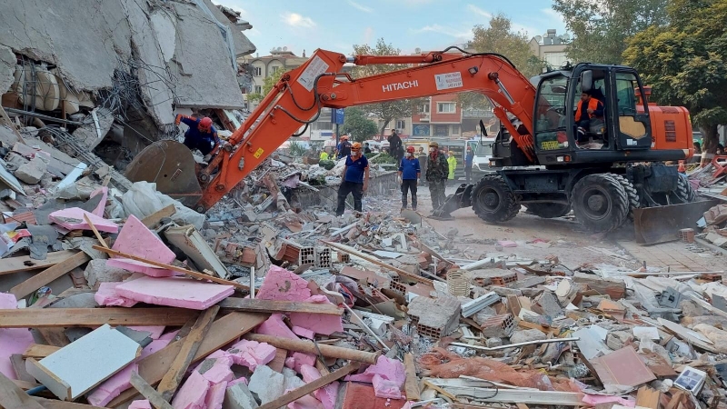 Personas buscan sobrevivientes en un edificio derrumbado después de que un fuerte terremoto sacudió el mar Egeo donde algunos edificios colapsaron en la provincia costera de Izmir, Turquía.