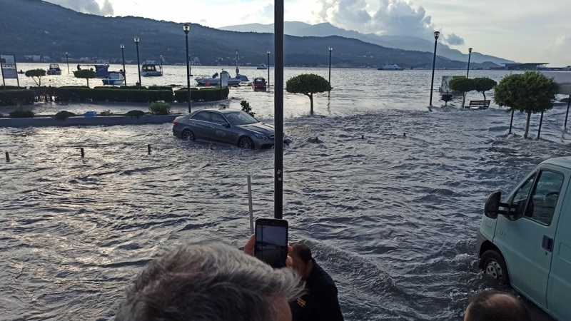 La gente se para en el paseo inundado de la ciudad portuaria de Vathy después de un terremoto, en la isla de Samos, Grecia.