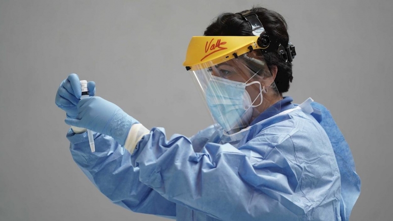 Un sanitario sostiene test rápido de antígenos en la mano.