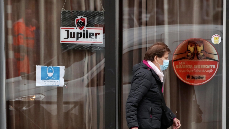 Una mujer pasa frente a un bar cerrado en Bruselas, bélgica–REUTERS