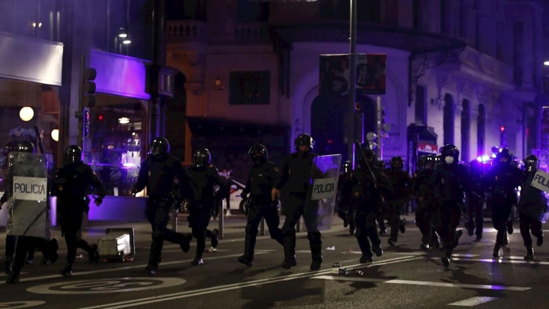 Miembros de la Policía Nacional recorren la Gran Via de Madrid durante los disturbios.